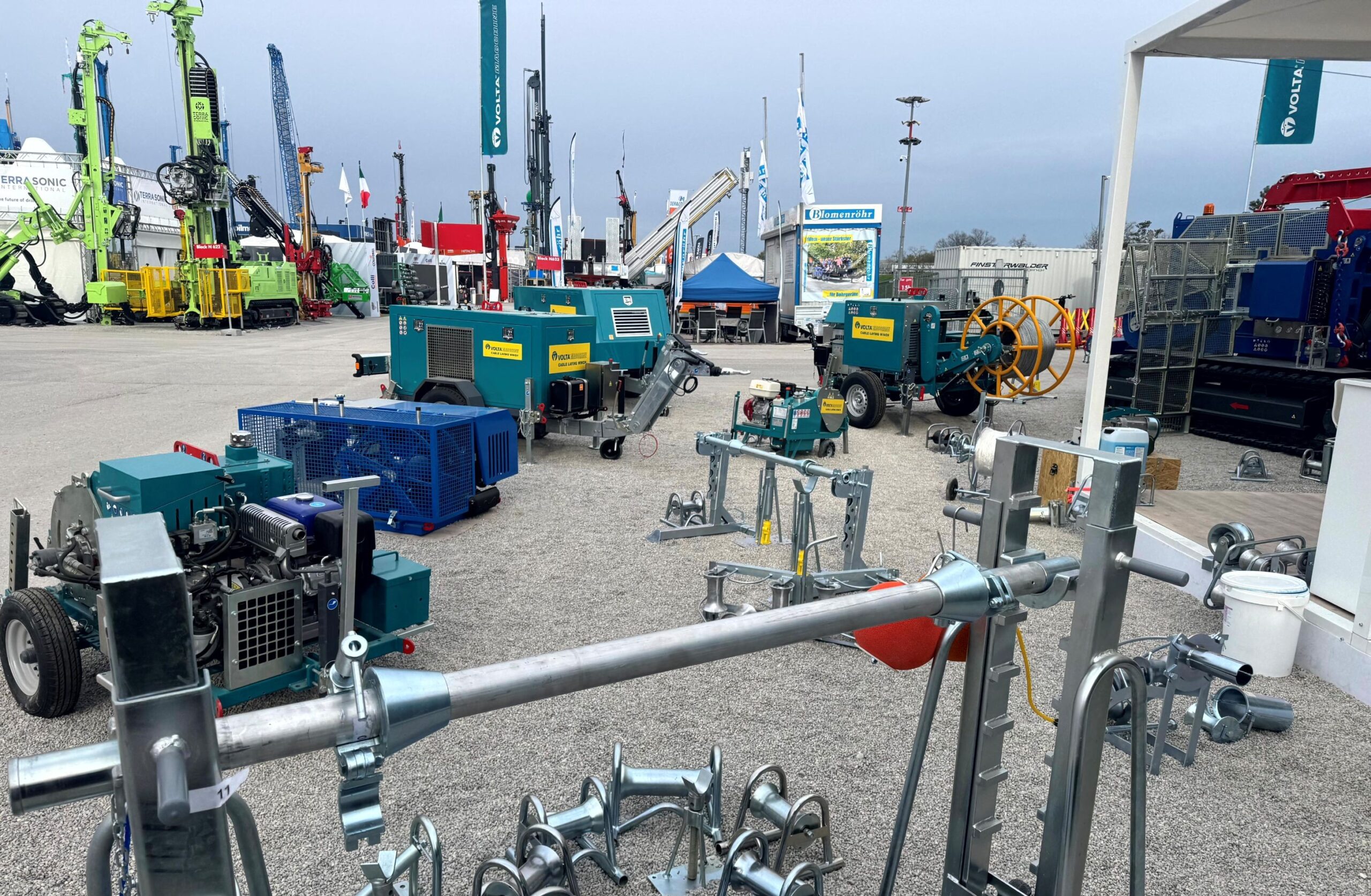 Exhibition display of mobile cable-pulling winches, cable drum stands, stringing equipment and utility installation accessories (incl. VOLTA) — complete solutions for fiber-optic and power network deployment.